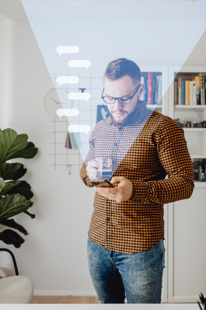 Services A man in casual attire using a smartphone, standing in a modern home office with overlay graphics.